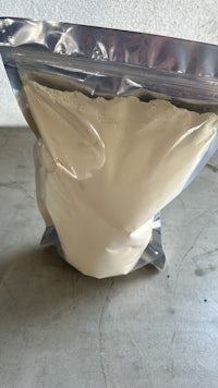 a bag of white powder sitting on a concrete floor